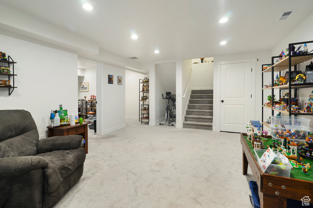 Carpeted living area featuring stairway and recessed lighting