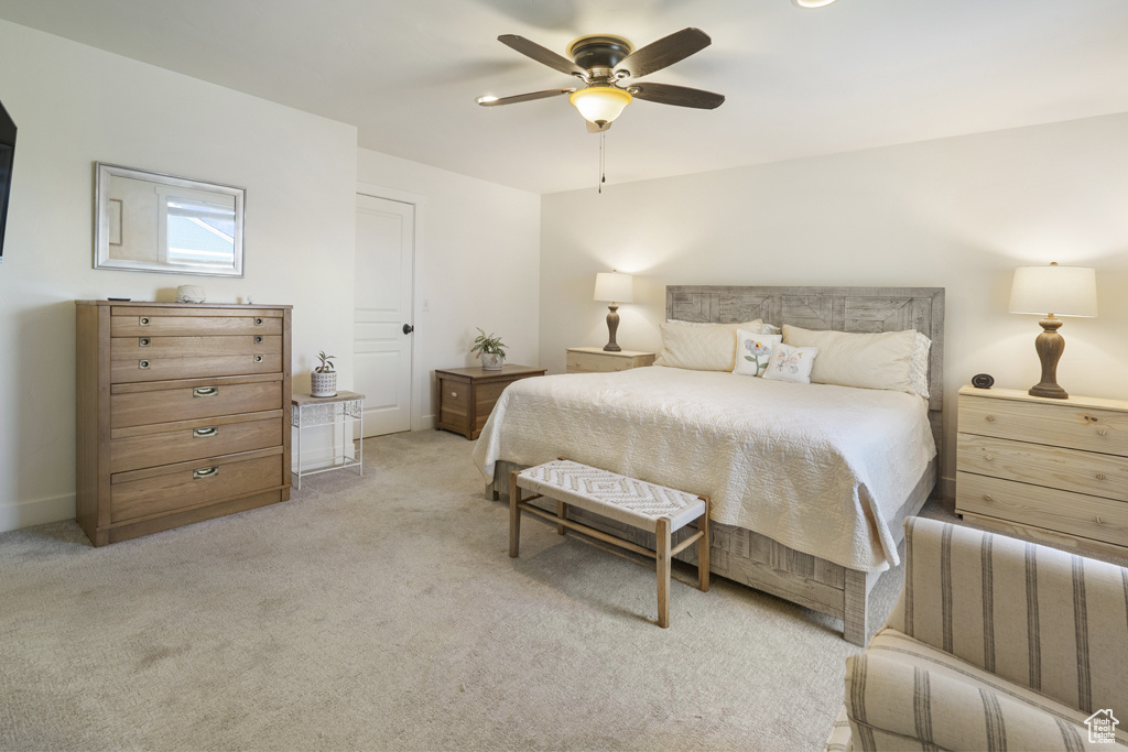 Bedroom with light colored carpet and a ceiling fan