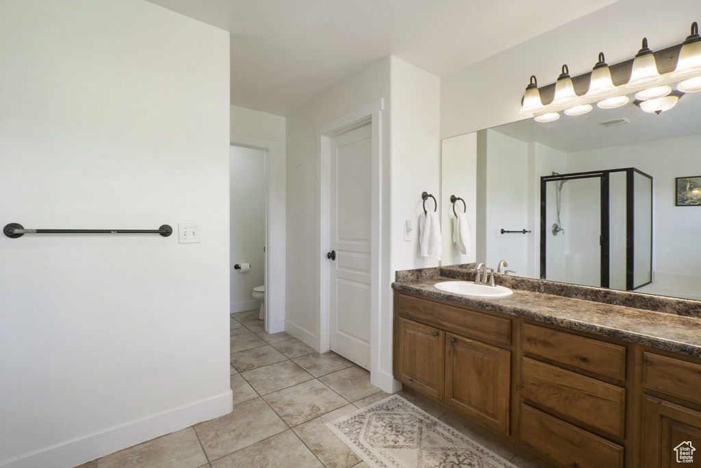 Bathroom featuring a shower stall, vanity, and tile patterned floors