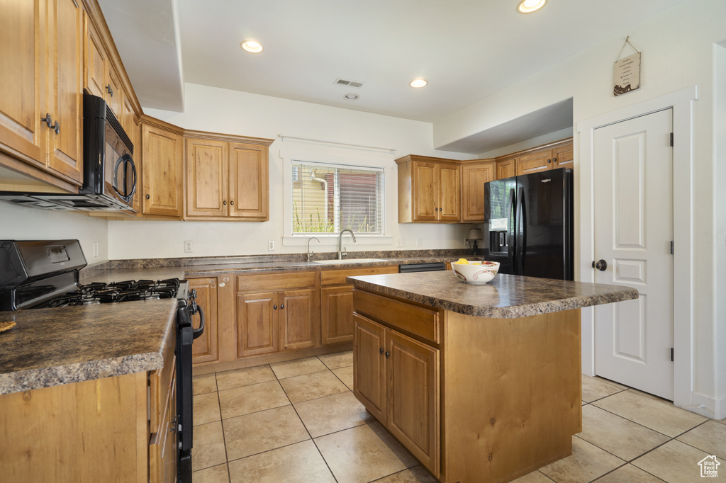 Kitchen featuring black appliances, dark countertops, light tile patterned floors, a center island, and recessed lighting