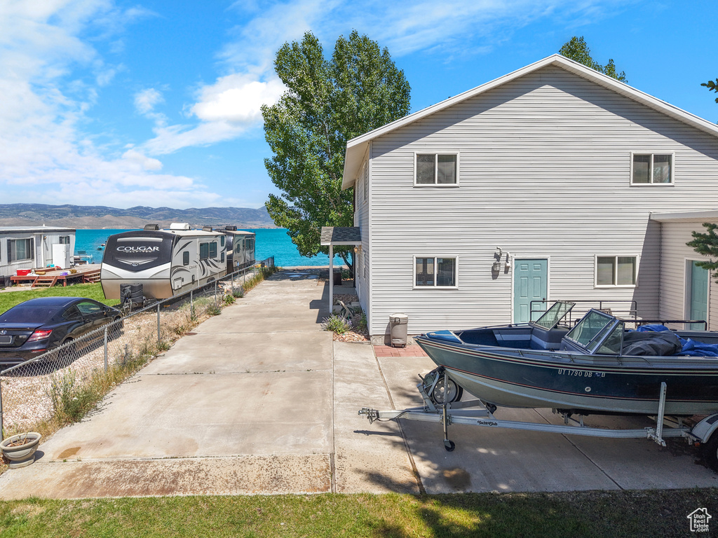 Back of property with a water and mountain view
