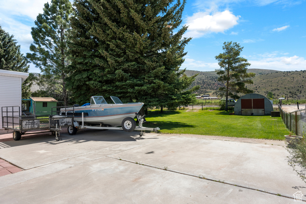 View of patio featuring a storage shed, a mountain view, and concrete driveway