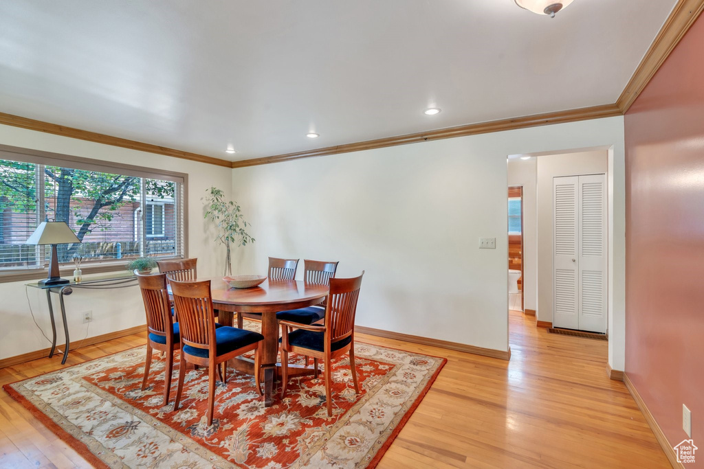 Dining area featuring light wood-style floors, ornamental molding, and recessed lighting