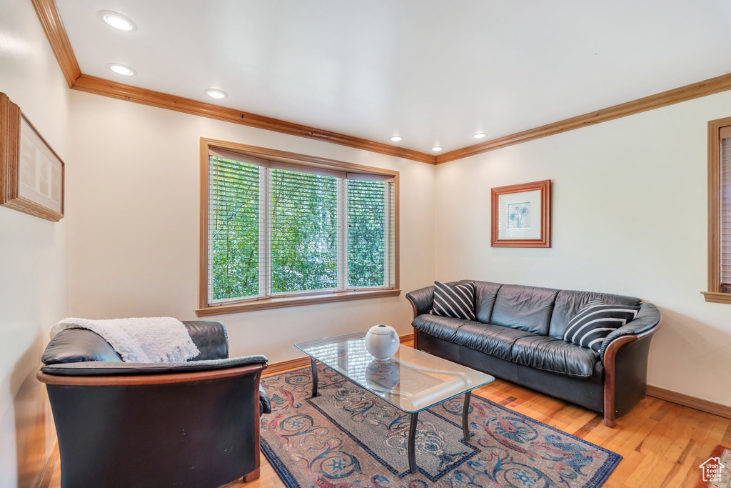 Living room featuring crown molding, wood finished floors, and recessed lighting