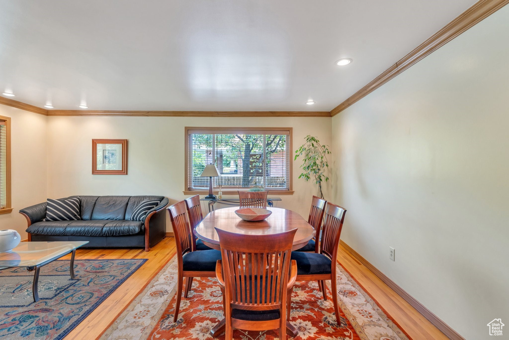 Dining room with light wood-type flooring, recessed lighting, and ornamental molding