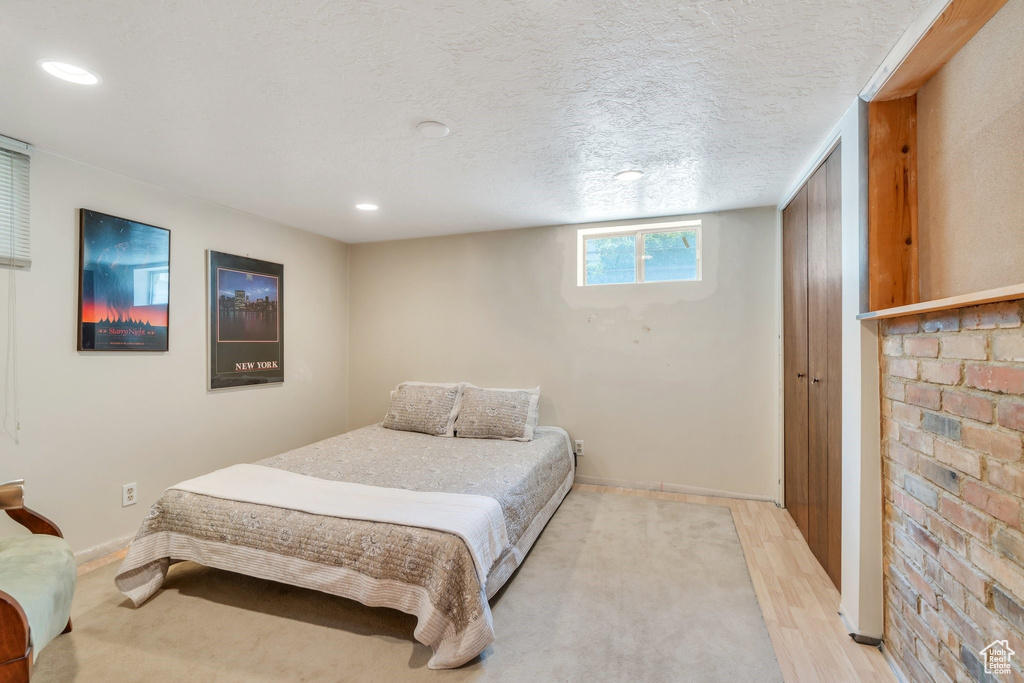 Bedroom with recessed lighting, light wood-type flooring, and a textured ceiling