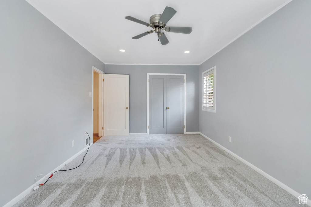 Unfurnished bedroom featuring carpet, recessed lighting, a closet, ceiling fan, and crown molding