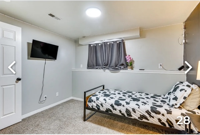Bedroom featuring carpet and baseboards