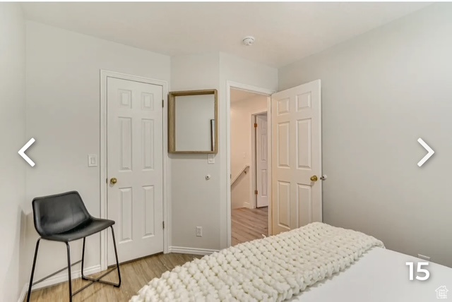 Bedroom with light wood finished floors and baseboards