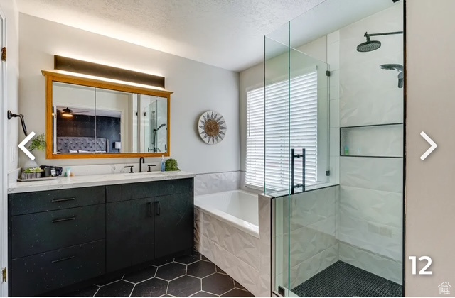 Full bathroom featuring vanity, a shower stall, tile patterned floors, a bath, and a textured ceiling