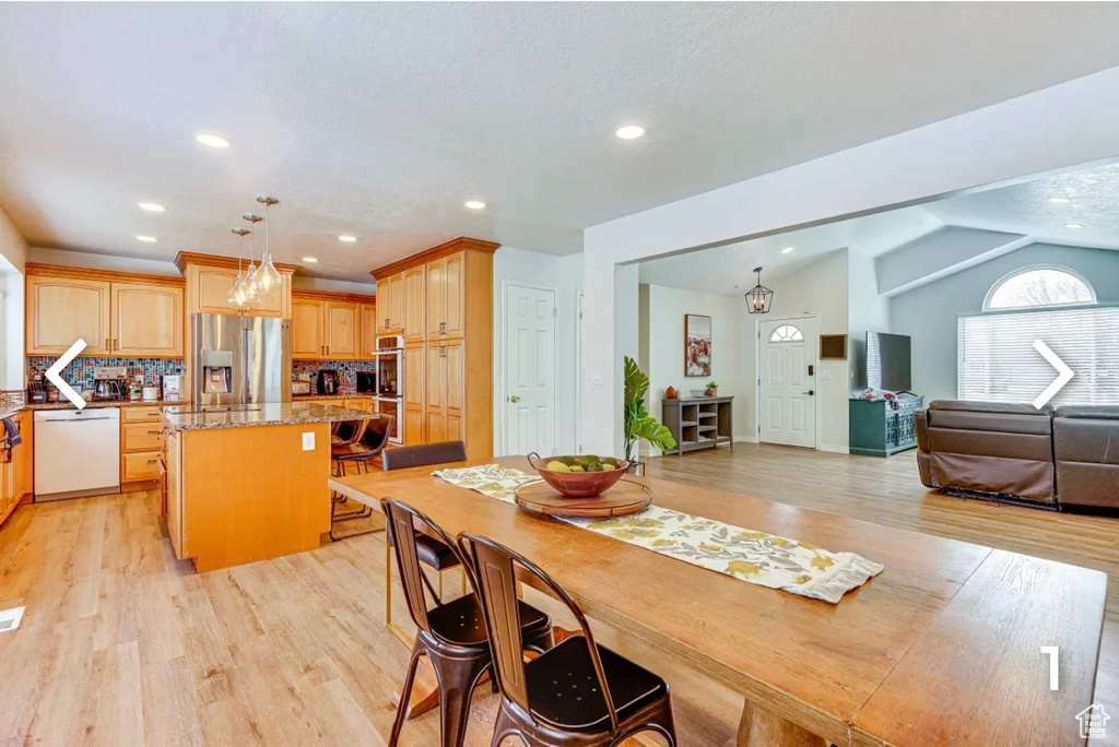 Dining area with light wood finished floors, recessed lighting, and lofted ceiling