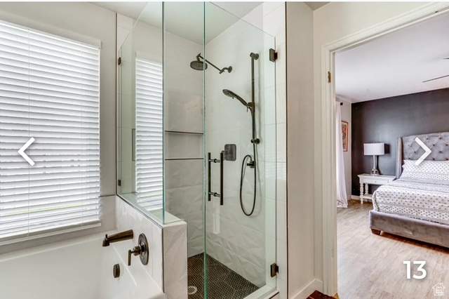 Ensuite bathroom with a bath, a stall shower, and wood finished floors