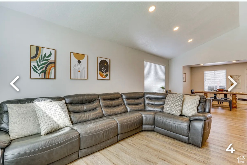 Living area featuring light wood-style flooring, recessed lighting, and vaulted ceiling