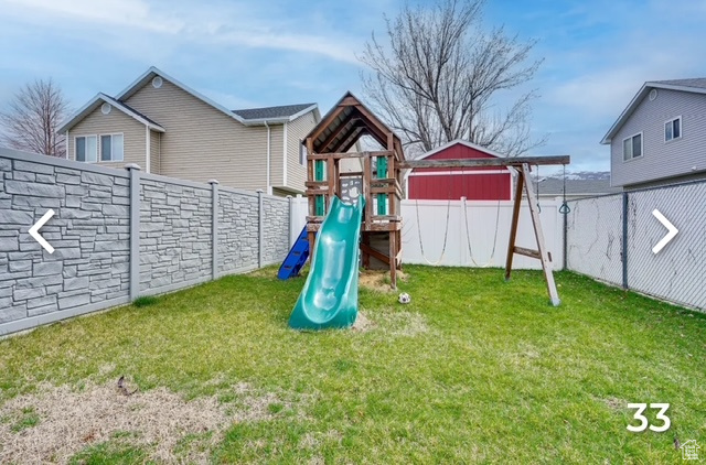 View of play area with a fenced backyard