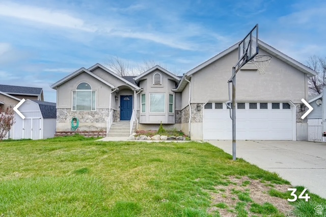 Ranch-style home with stucco siding, stone siding, a shed, concrete driveway, and an attached garage