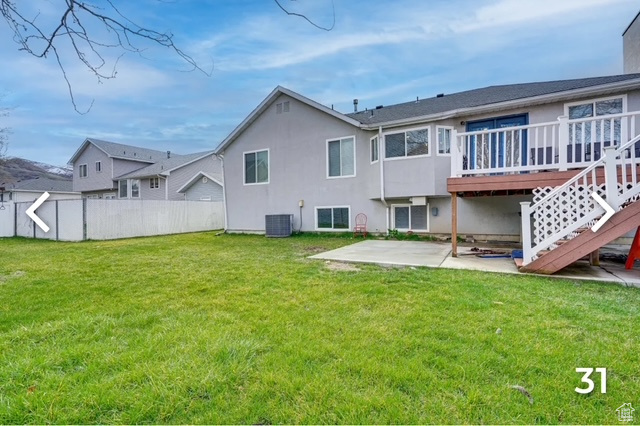 Rear view of property featuring a patio, a wooden deck, and stucco siding
