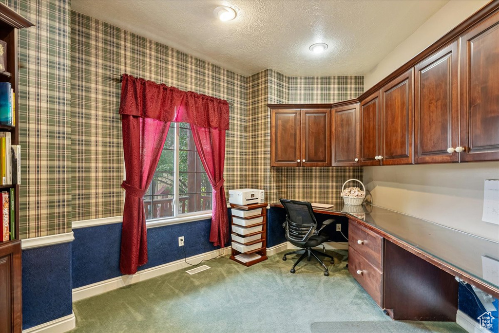 Office with built in desk, carpet floors, a textured ceiling, wallpapered walls, and recessed lighting