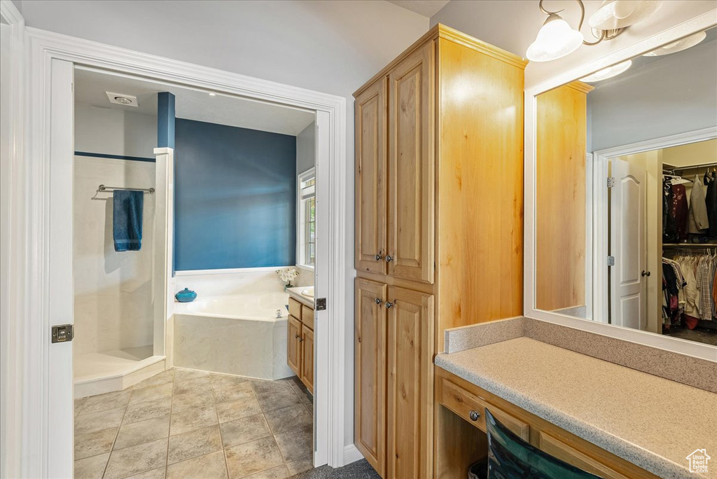 Bathroom with a bath, a shower stall, vanity, and a spacious closet