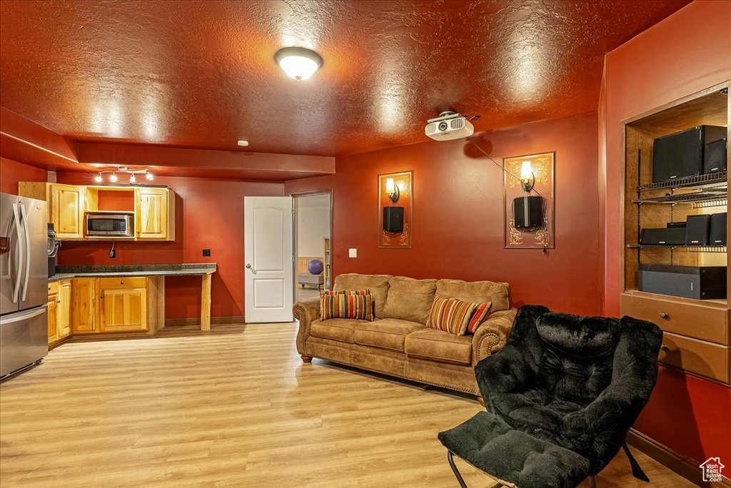 Living area with light wood-style floors and a textured ceiling