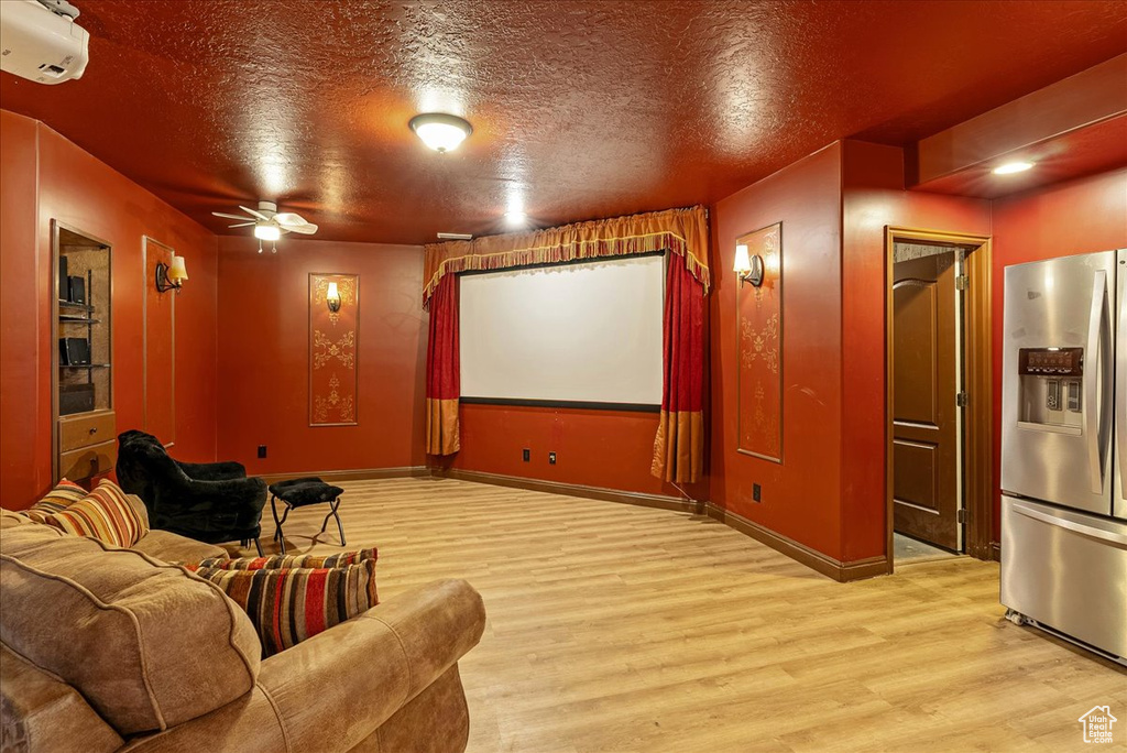 Cinema with wood finished floors, a ceiling fan, a textured ceiling, and a wall mounted AC