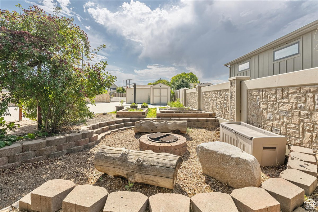 View of patio with a garden and a storage shed