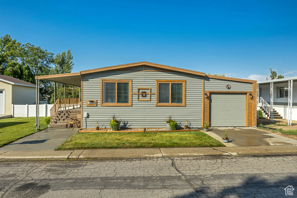 View of front of property featuring a garage, concrete driveway, and stairway