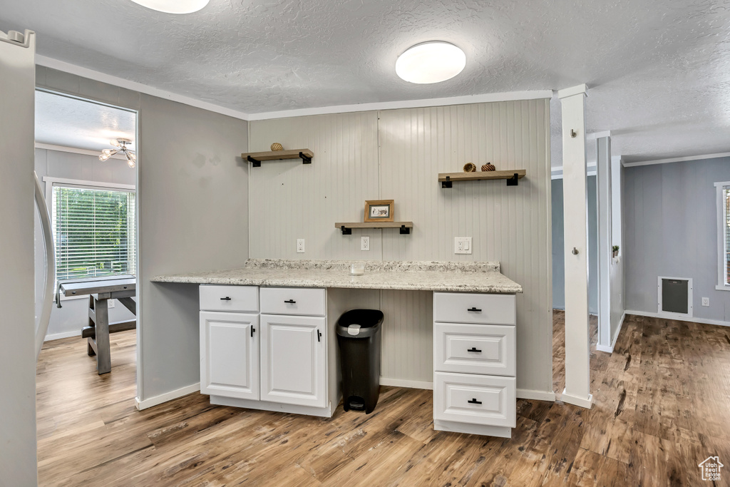 Bathroom with a textured ceiling, wood finished floors, ornamental molding, and vanity