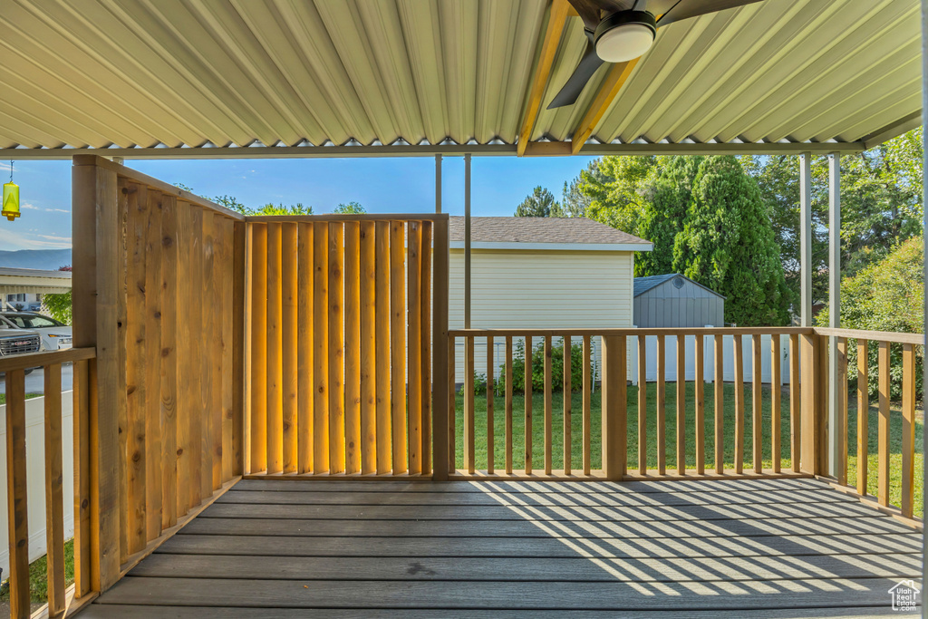 Deck featuring a ceiling fan and a storage shed