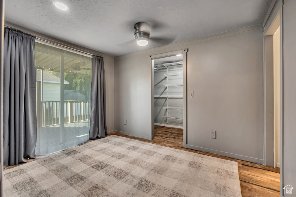 Spare room featuring wood finished floors, a ceiling fan, and ornamental molding