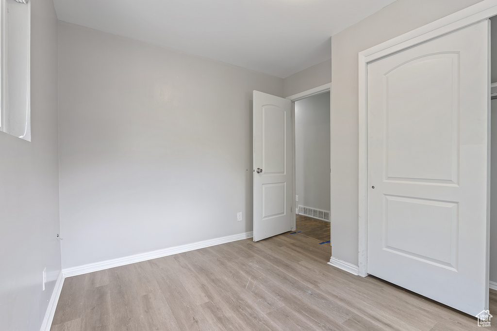 Unfurnished bedroom featuring light wood-type flooring and a closet