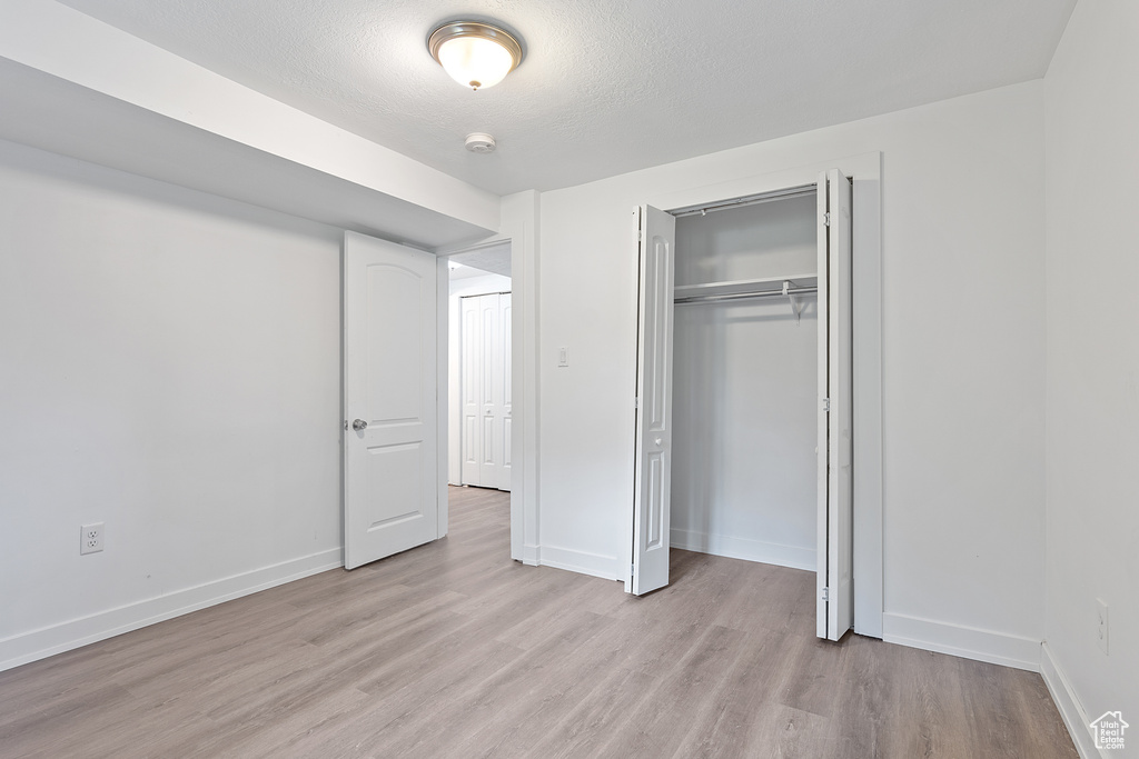 Unfurnished bedroom with light wood-style flooring and a closet