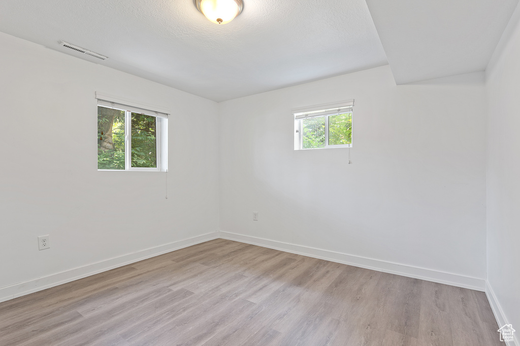Unfurnished room featuring light wood-style flooring and a textured ceiling