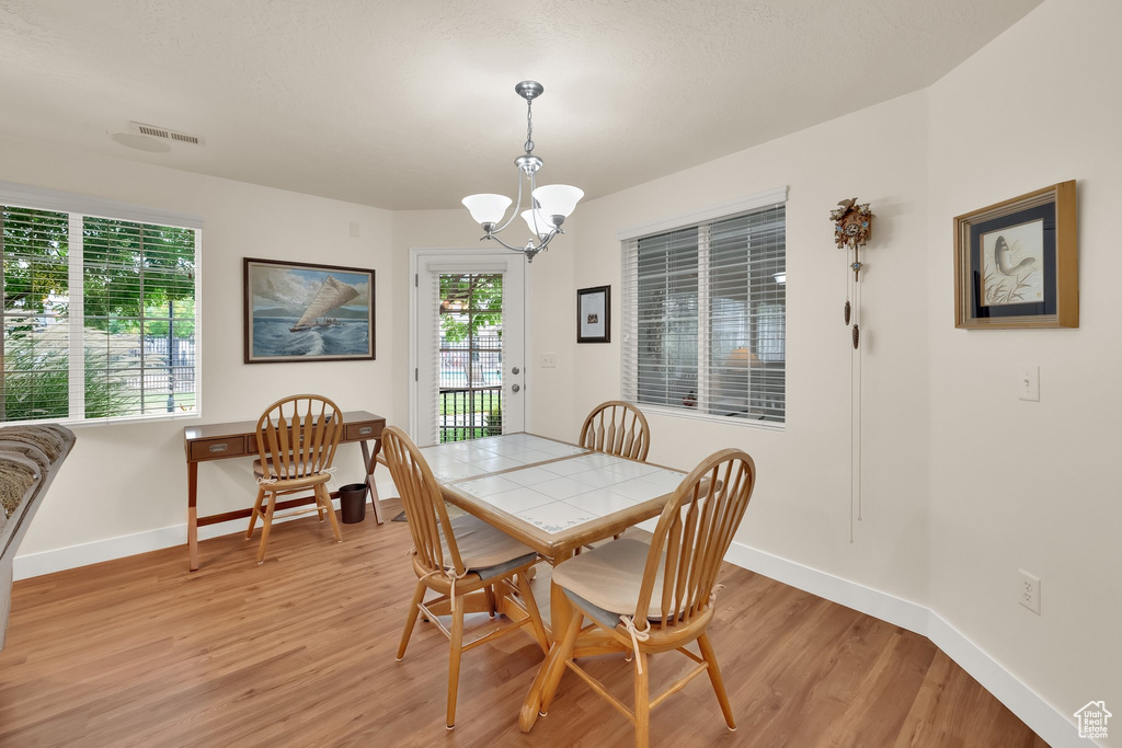Dining room featuring light wood finished floors and a chandelier