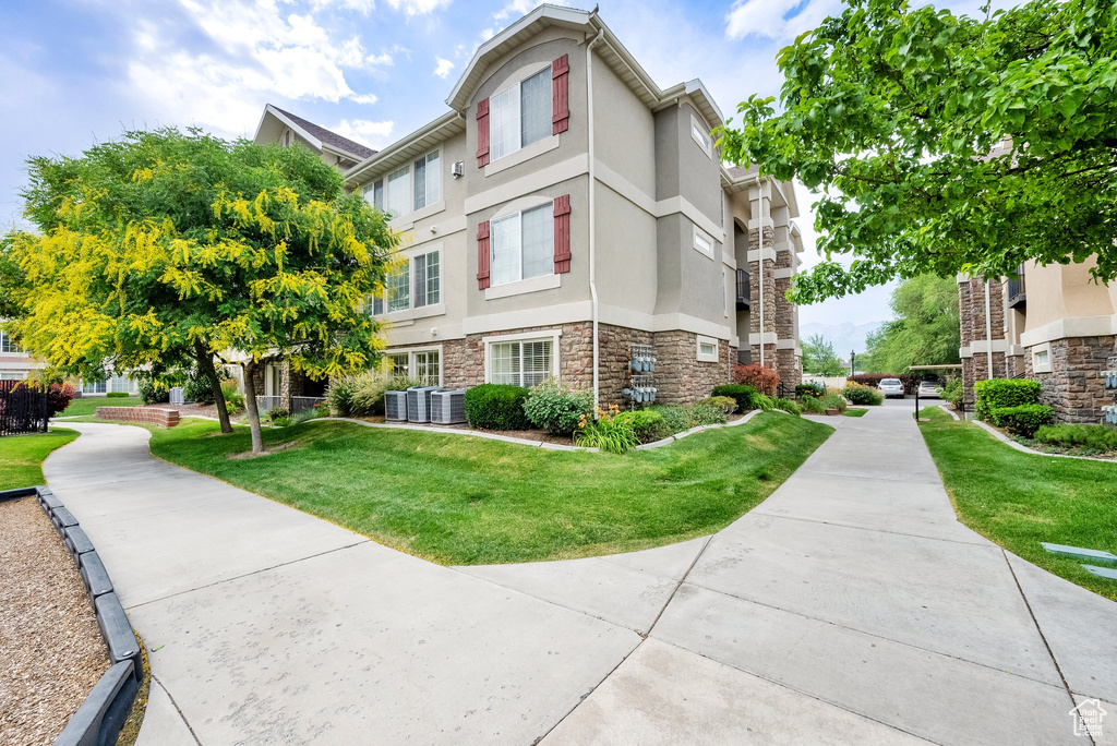 View of home\\\\\\\'s exterior featuring stone siding, stucco siding, and a lawn