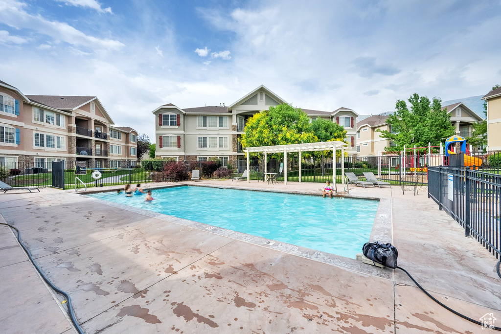 Community pool with a residential view, a pergola, and a patio area
