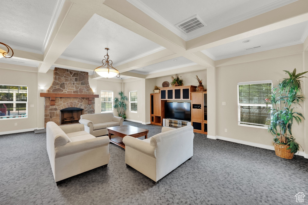 Living room with crown molding, coffered ceiling, beamed ceiling, and a stone fireplace