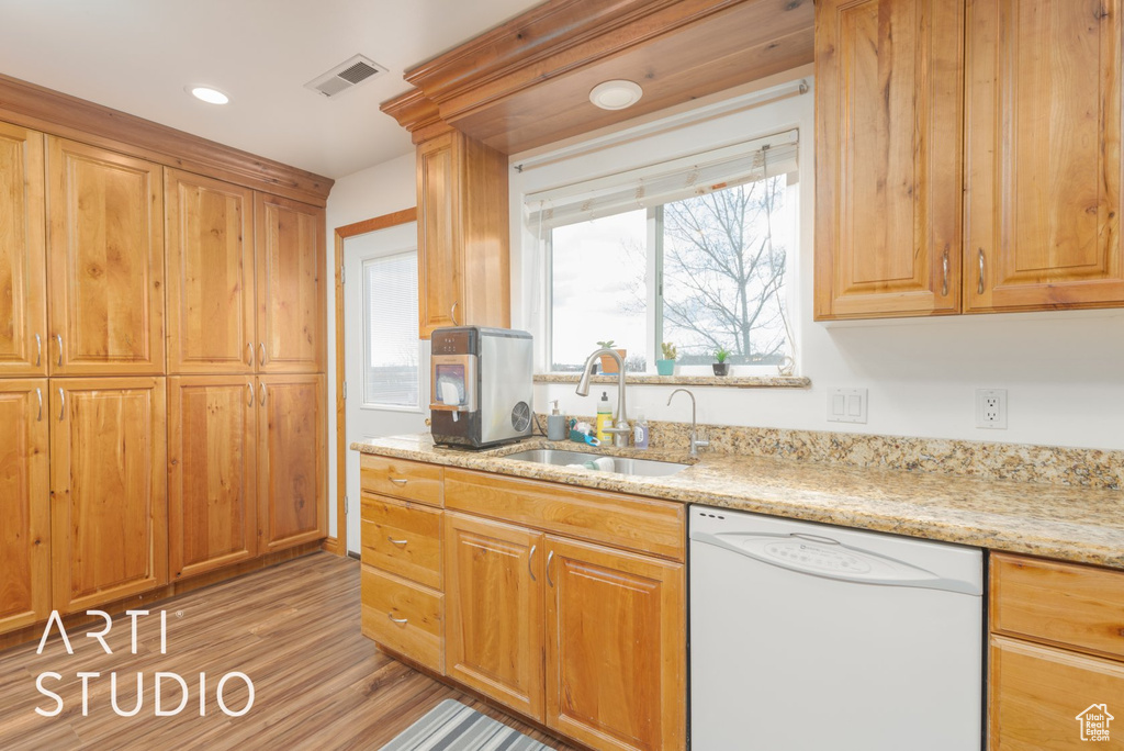 Kitchen with dishwasher, light wood-style floors, light stone counters, and recessed lighting