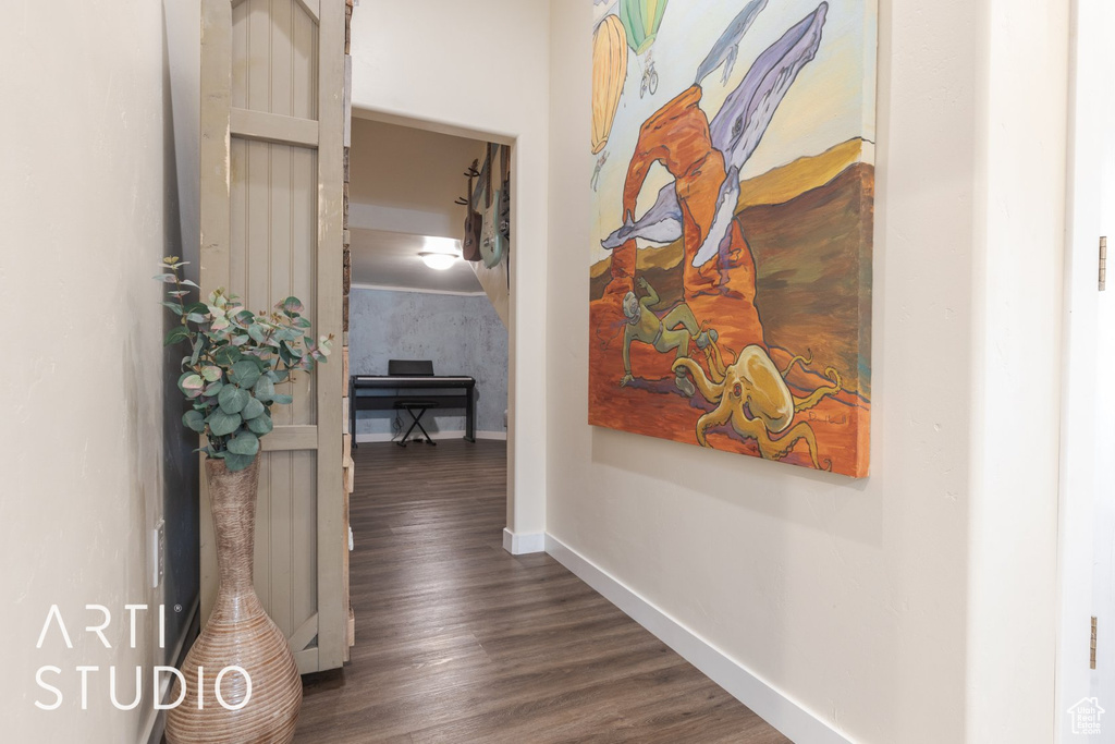 Hallway with baseboards and dark wood-type flooring