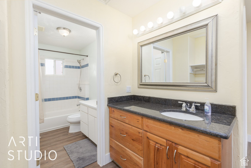 Bathroom featuring vanity, wood finished floors, and shower / bath combination
