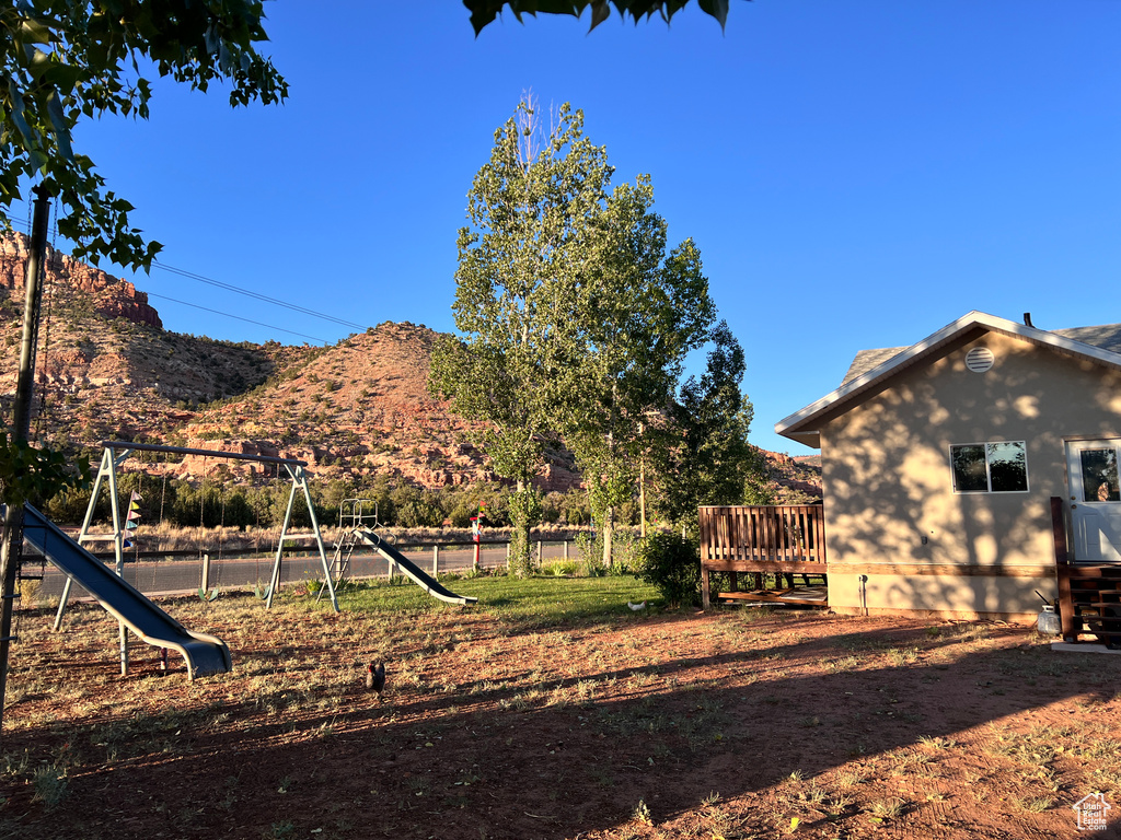 View of yard featuring a playground and a mountain view