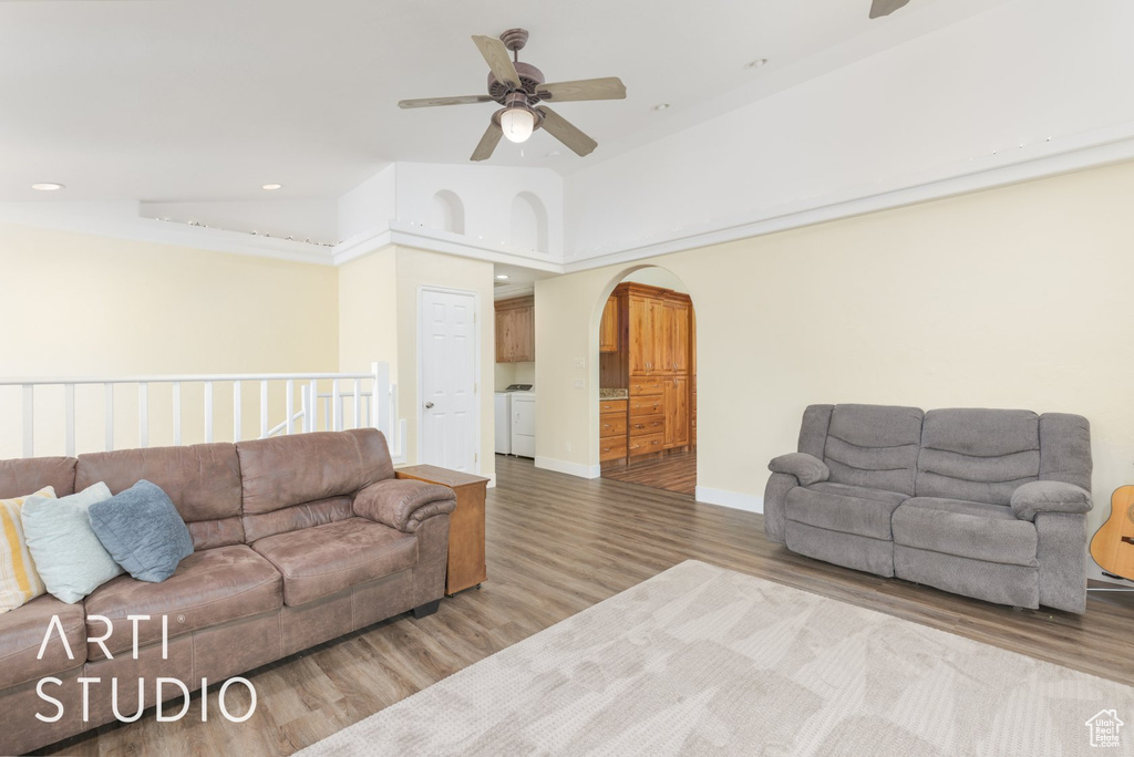 Living room with ceiling fan, wood finished floors, arched walkways, and recessed lighting