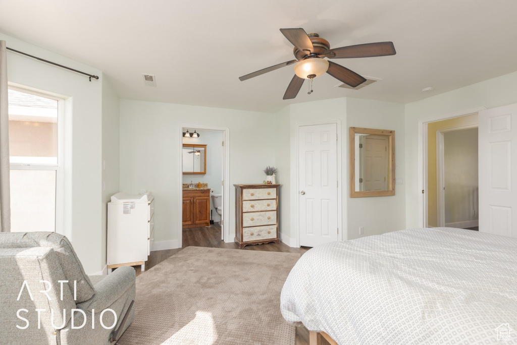 Bedroom with wood finished floors, ceiling fan, and ensuite bath