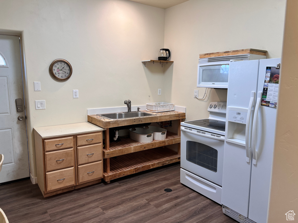Kitchen featuring white appliances, dark wood-style floors, light countertops, and brown cabinetry