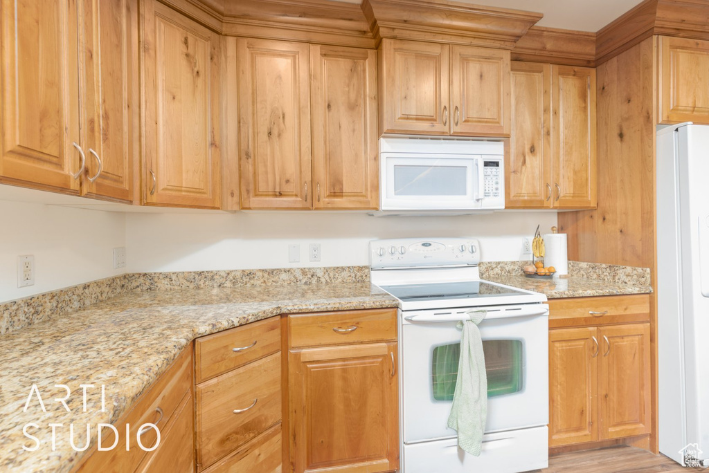 Kitchen featuring white appliances and light stone countertops
