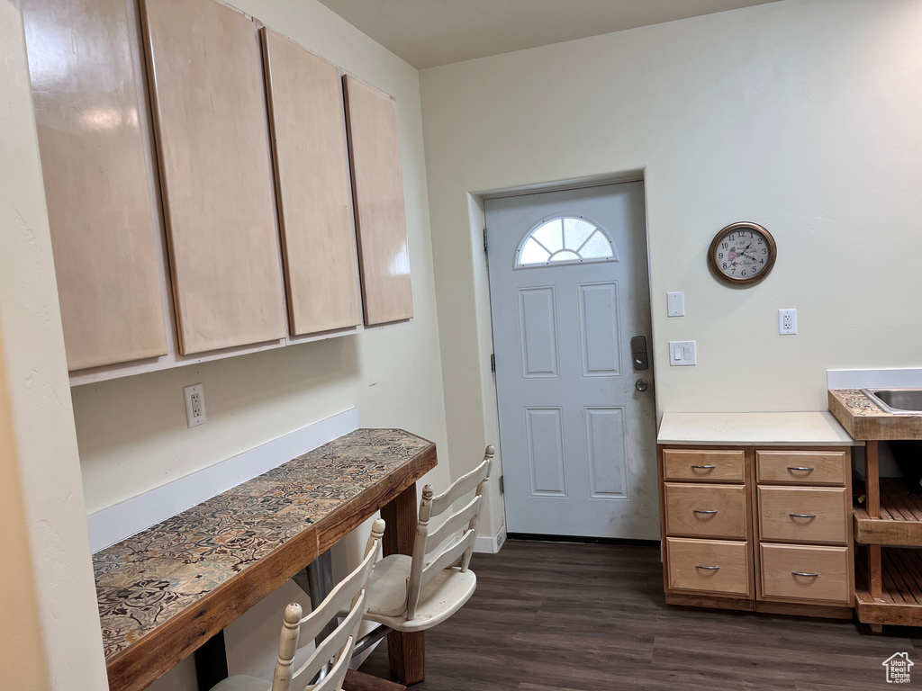 Foyer featuring dark wood-style flooring and baseboards