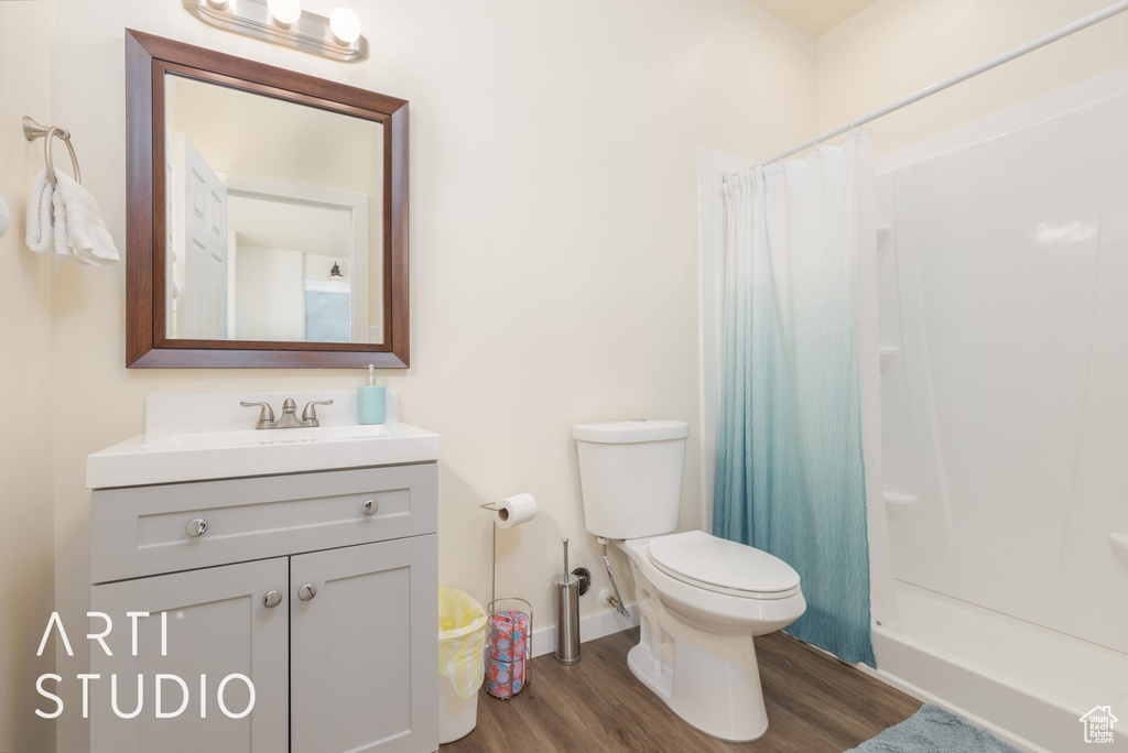Full bath with wood finished floors, vanity, and shower / bathtub combination with curtain