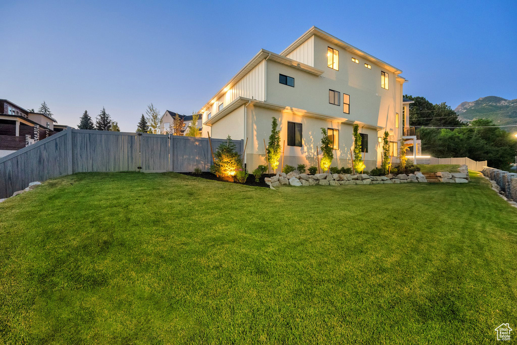 Back of property with a fenced backyard and stucco siding