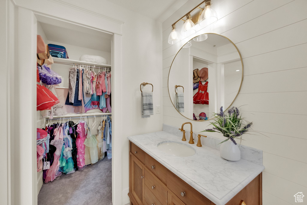 Bathroom with vanity and a spacious closet