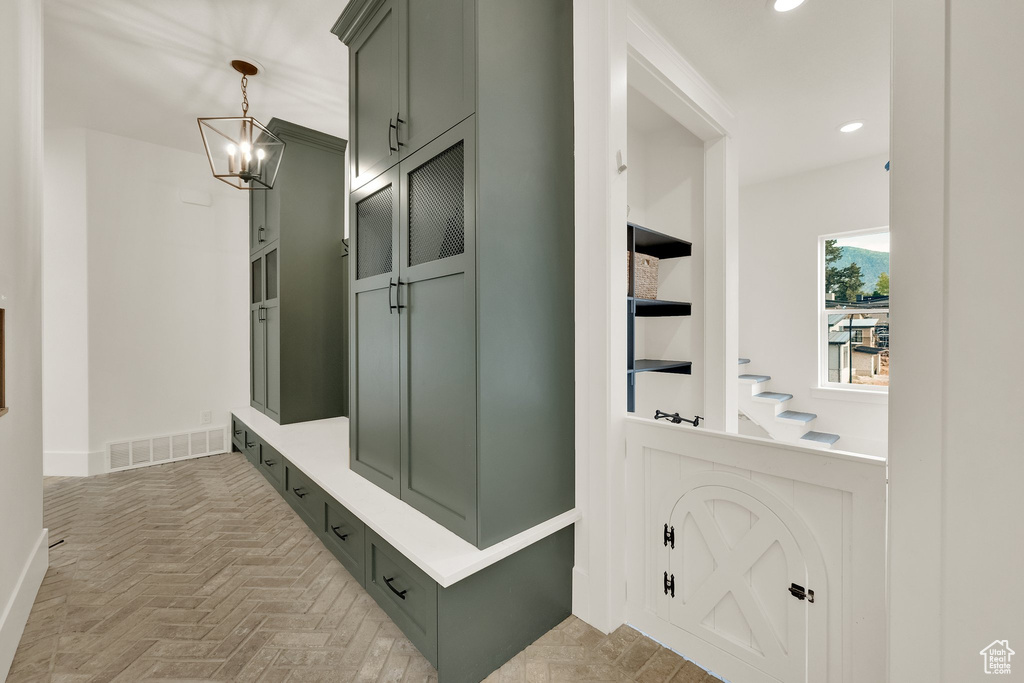 Mudroom with recessed lighting, a chandelier, and built in shelves