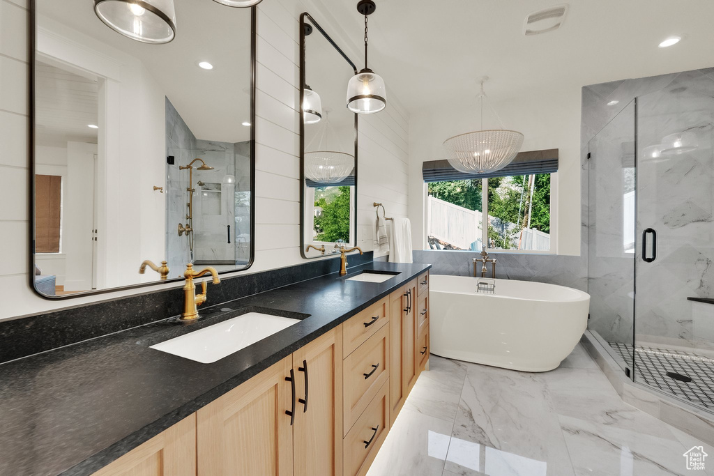 Bathroom featuring a marble finish shower, a freestanding bath, double vanity, recessed lighting, and marble tiled flooring